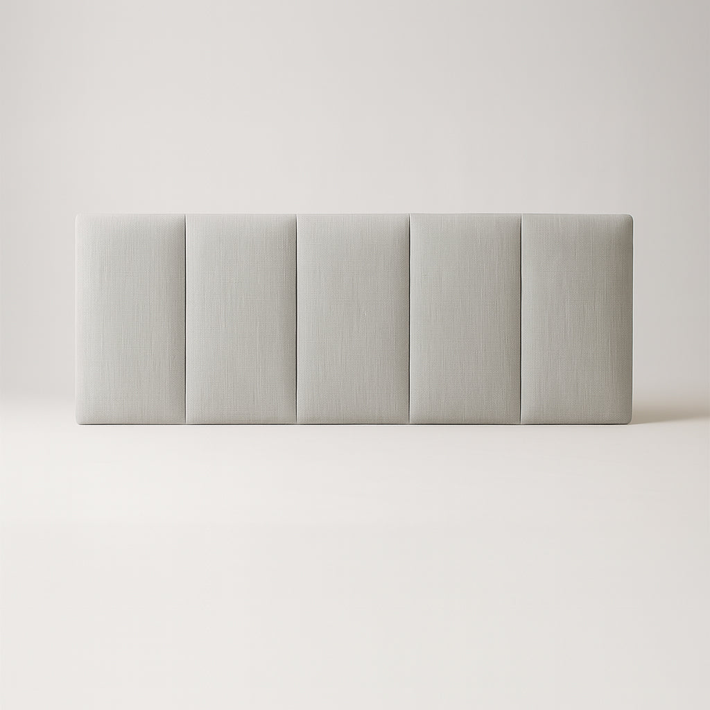 Gray upholstered headboard on a bed with a plain background